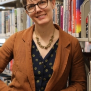 white woman with brown bangs and glasses