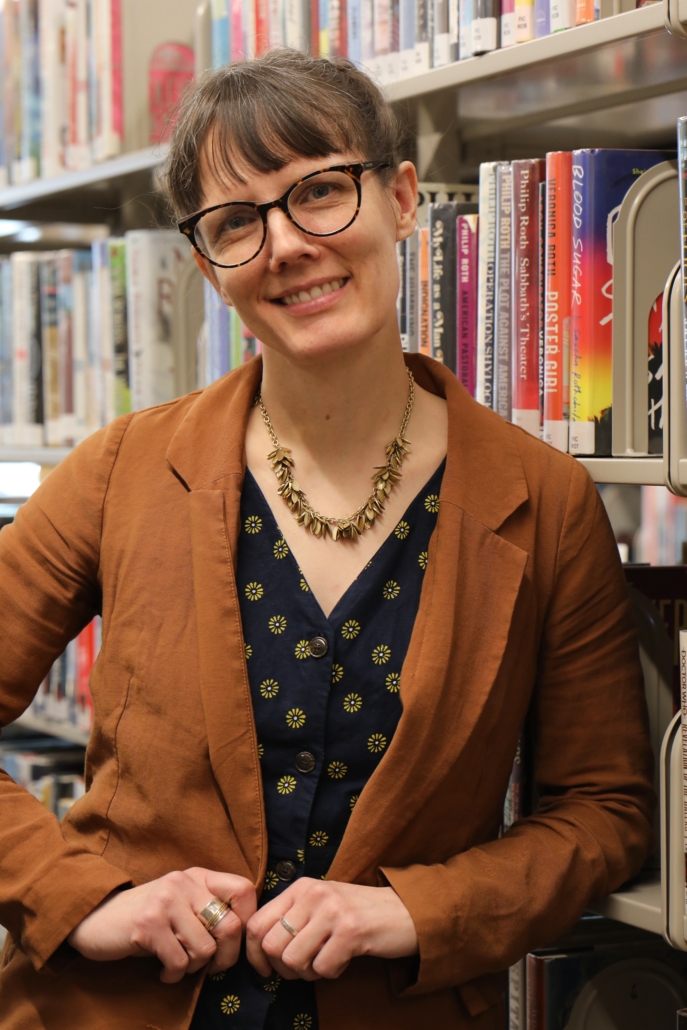 white woman with brown bangs and glasses