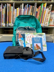 green backpack with books and binoculars