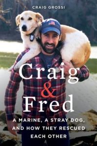 Man in beard and blue hat with a golden labrador on his shoulders